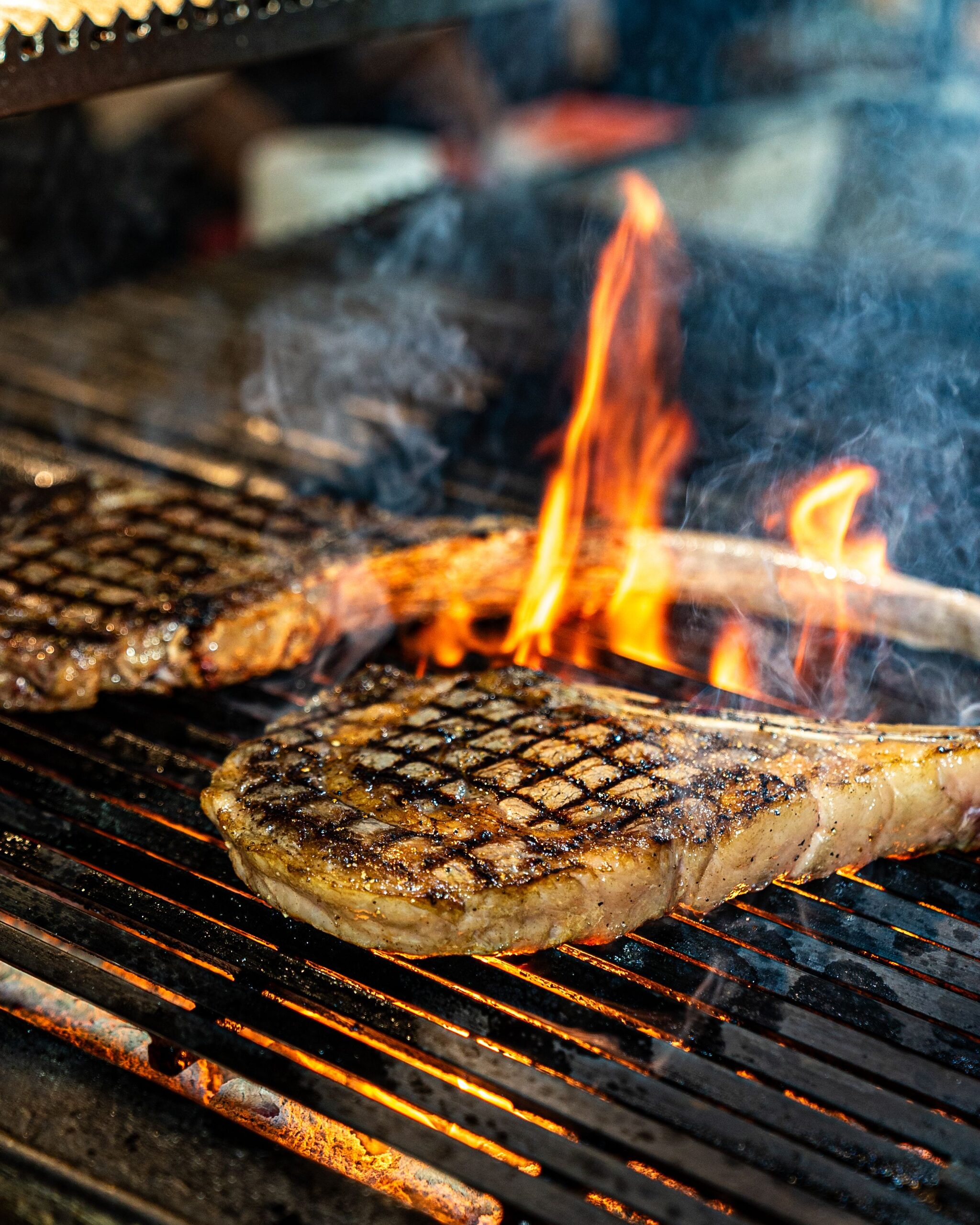 A steak on a grill over open flames